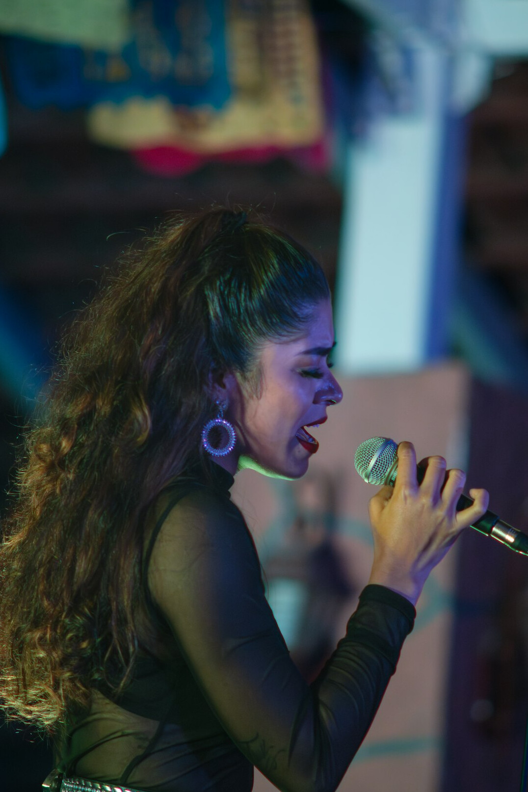Fashionable Latina singer performing on stage with microphone